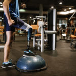 Disabled young man training in the gym. Disabled sportsman Concept.