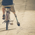 Amputee on a bicycle in vintage tone